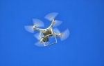 Drohne im Flug vor blauem Himmel